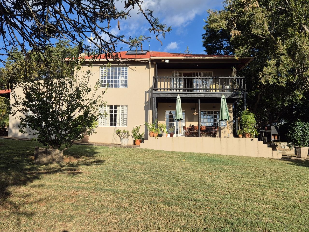 Außenansicht des zweistöckigen Homestead mit Balkon und gepflegtem Rasen