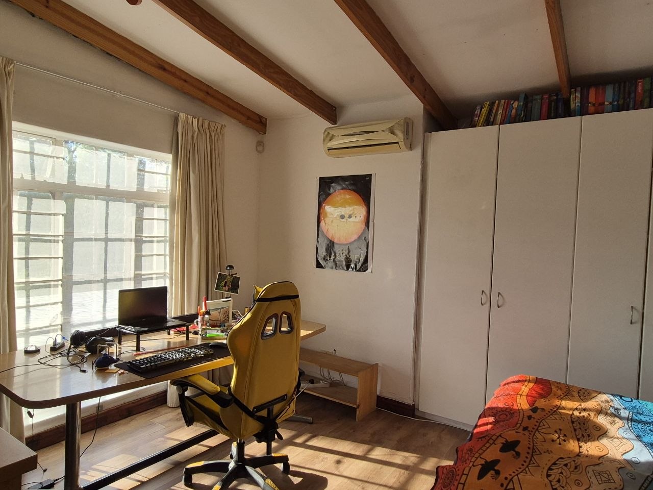 Arbeitszimmer mit Schreibtisch, Monitor und Klimaanlage